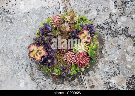 Bouquet de fleurs en céramique sur une tombe dans un cimetière français Banque D'Images