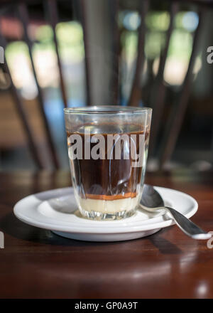 Tradition thaïlandaise café chaud avec le lait condensé sucré dans old style cup, servi sur table en bois. Banque D'Images