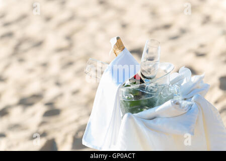 Bouteille de champagne et des verres à vin dans la benne d'installation sur la plage. Libre. Banque D'Images