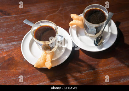 Tradition thaïlandaise café chaud avec le lait condensé sucré dans old style cup, servi sur table en bois. Banque D'Images