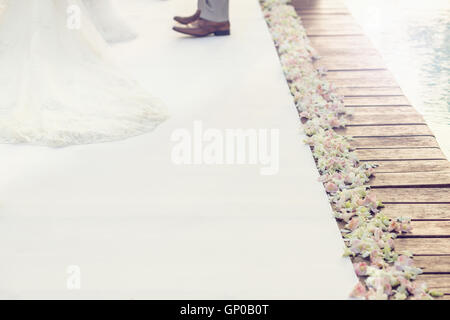 Blanc douceur passerelle sur coffret bois pont pour cérémonie de mariage, de belles fleurs sur le côté, avec l'arrière-plan flou pa Banque D'Images