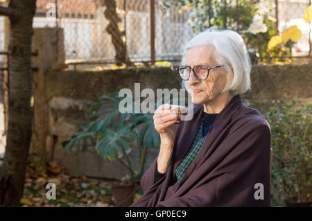 Senior woman having tasse de café en plein air Banque D'Images