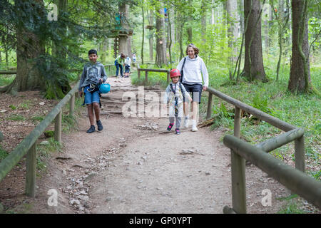 Mère et enfants marcher dans la forêt pendant des activités d'accrobranche Banque D'Images