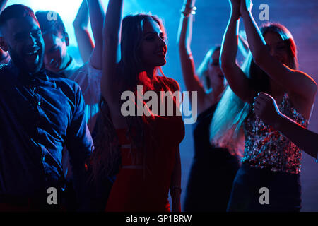 Groupe de cheerful friends enjoying discothèque Banque D'Images