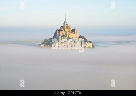 VUE AÉRIENNE.Abbaye sur un pic isolé au-dessus du brouillard du matin.Mont Saint-Michel, Manche, Normandie, France. Banque D'Images