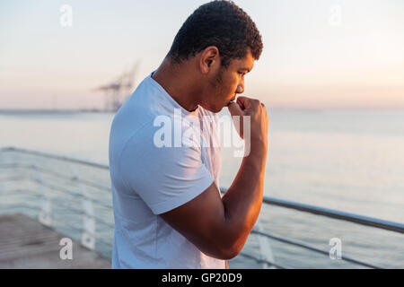 African American jeune homme sportif pratiquant shadow boxing sur pier Banque D'Images