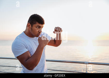 Concentrés african american man shadow boxing boxeur pratiquant à l'extérieur dans la matinée Banque D'Images