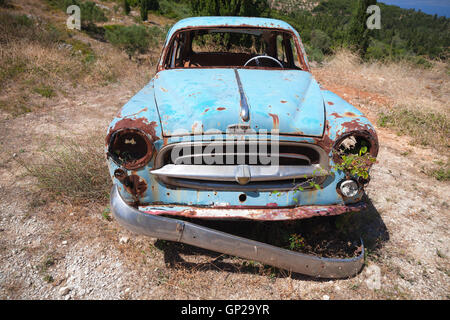 Zakynthos, Grèce - 20 août 2016 : Vieille voiture rouillée abandonnée se trouve dans un jardin d'été, vue avant Banque D'Images