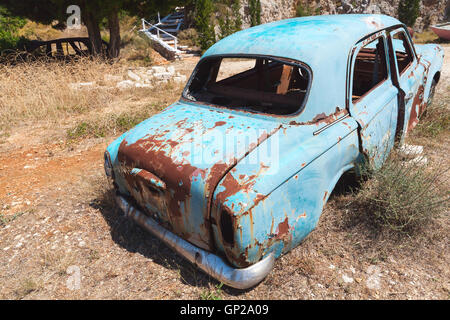 Vieille voiture rouillée abandonnée se trouve dans un jardin d'été, vue arrière Banque D'Images