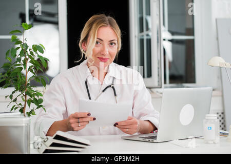 Mid adult female doctor lire des documents Office Banque D'Images