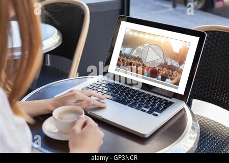 Streaming vidéo en ligne, concert, femme regardant un clip de musique sur Internet sur ordinateur portable en cafe Banque D'Images