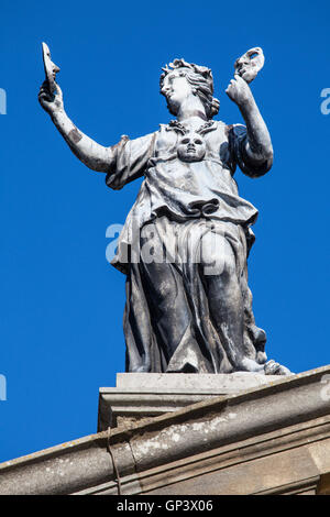 Une ancienne statue d'un acteur tenant le masque haut de The Clarendon Building dans le centre-ville historique d'Oxford, en Angleterre. Banque D'Images