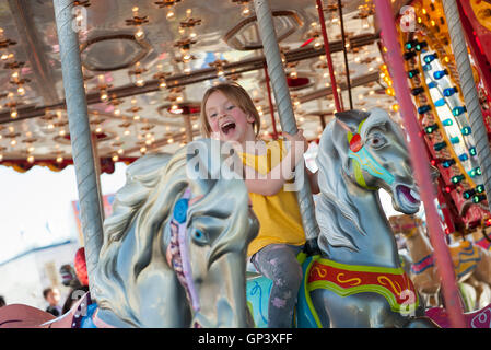 Little girl riding on carousel Banque D'Images