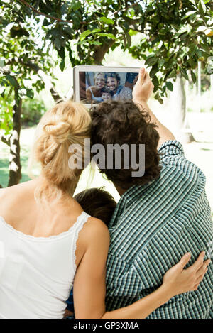 Famille avec un enfant posant pour prises selfies with digital tablet Banque D'Images