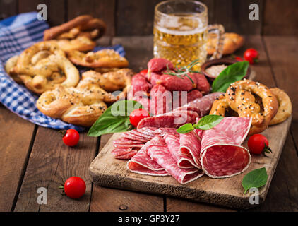 Verre de bière, les bretzels et diverses saucisses sur fond de bois. L'Oktoberfest. Banque D'Images