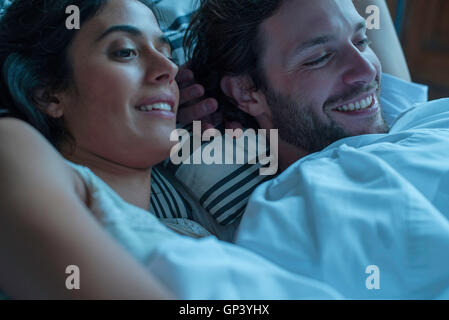 Couple watching tv together in bed Banque D'Images