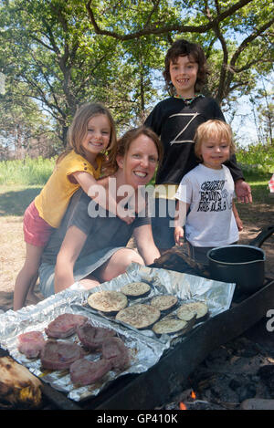 La mère et les enfants à l'ensemble de cuisson camping Banque D'Images