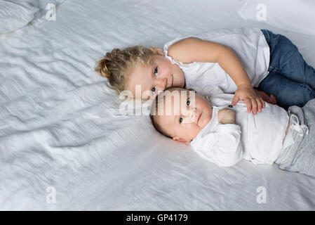 Petite fille de câlins avec bébé frère Banque D'Images