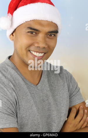 Young Filipino wearing a Santa hat smiling Banque D'Images