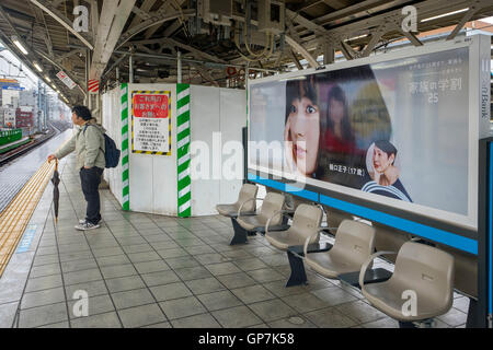 L'homme en attente de train sur la plate-forme, Tokyo, Japon Banque D'Images