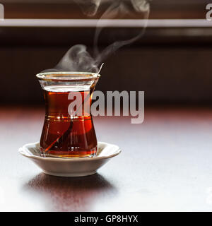 Une tasse de thé turc sur une table avec de la vapeur au-dessus Banque D'Images