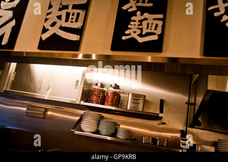 Pots de piments rouges dans l'aire de préparation des repas d'un restaurant de nouilles à Tokyo, Japon Banque D'Images