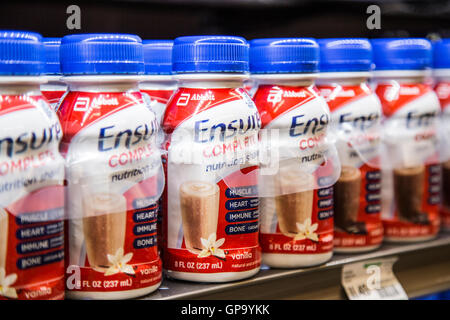 Bouteilles d'assurer la nutrition shakes dans une rangée sur une étagère dans une épicerie Banque D'Images