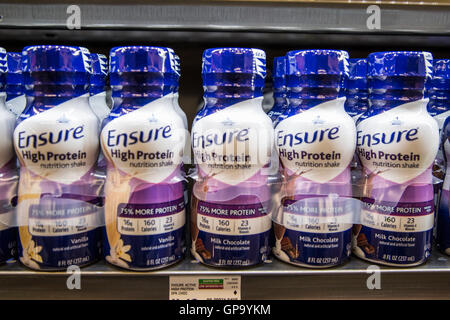 Bouteilles d'assurer la nutrition shakes dans une rangée sur une étagère dans une épicerie Banque D'Images