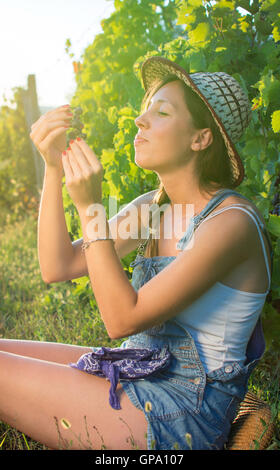 Happy woman enjoying raisins frais à vineyard Banque D'Images