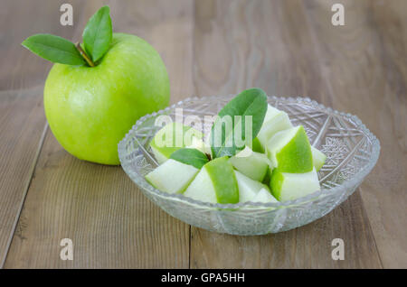 Ripe green apple avec la feuille et coupe sur un fond de bois Banque D'Images