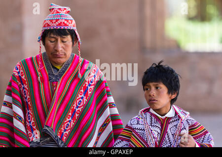 Pisac, Pérou - 15 mai : l'homme qui marche avec son fils vêtu de beaux vêtements traditionnels dans le marché de Pisac. Le 15 mai 201 Banque D'Images