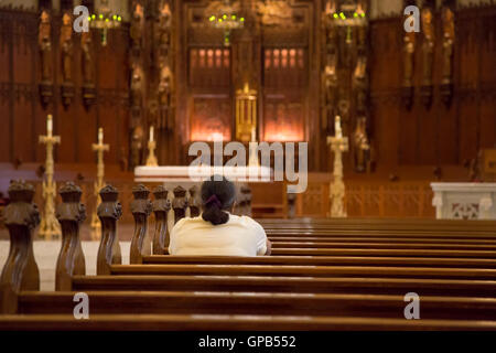 Fort Wayne, Indiana - une femme prie dans la Cathédrale de l'Immaculée Conception. Banque D'Images