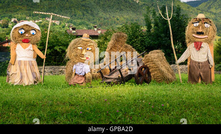 Belle famille agriculteurs(Marionnettes poupées de paille) faite de balles de foin avec des vêtements de paysans en Europe l'automne,square photo. Banque D'Images