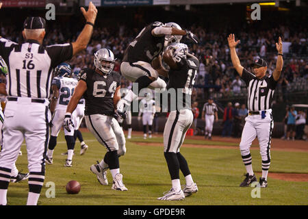 2 Septembre, 2010 ; Oakland, CA, USA ; Oakland Raiders wide receiver Johnnie Lee Higgins (15) est félicité par running back Michael Bennett (32) après avoir marqué un touché contre les Seattle Seahawks durant le premier trimestre au Oakland-Alameda County Co Banque D'Images