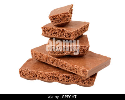 Pile de morceaux de chocolat au lait poreux isolated on white Banque D'Images