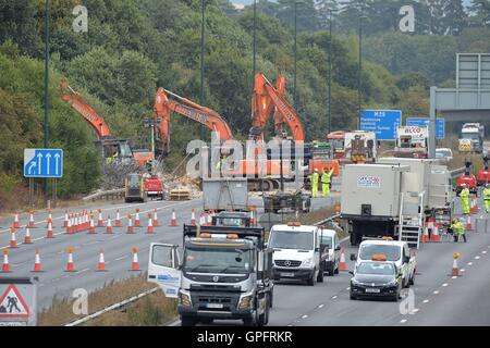 Les travailleurs du chantier de démolition déposer le reste de la structure de la passerelle au-dessus de l'autoroute M20 dans le Kent, qui a été fermée dans les deux directions pour permettre à la voirie de l'Angleterre pour effectuer le travail. Banque D'Images