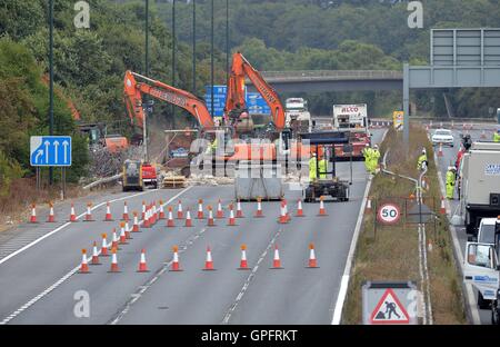 Les travailleurs du chantier de démolition déposer le reste de la structure de la passerelle au-dessus de l'autoroute M20 dans le Kent, qui a été fermée dans les deux directions pour permettre à la voirie de l'Angleterre pour effectuer le travail. Banque D'Images