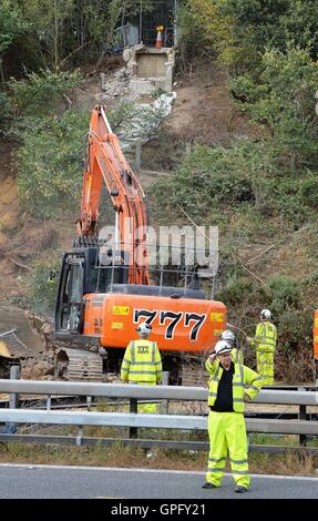 Les travailleurs du chantier de démolition déposer le reste de la structure de la passerelle au-dessus de l'autoroute M20 dans le Kent, qui a été fermée dans les deux directions pour permettre à la voirie de l'Angleterre pour effectuer le travail. Banque D'Images