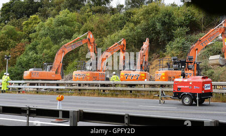 Les travailleurs du chantier de démolition déposer le reste de la structure de la passerelle au-dessus de l'autoroute M20 dans le Kent, qui a été fermée dans les deux directions pour permettre à la voirie de l'Angleterre pour effectuer le travail. Banque D'Images