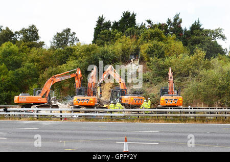 Les travailleurs du chantier de démolition déposer le reste de la structure de la passerelle au-dessus de l'autoroute M20 dans le Kent, qui a été fermée dans les deux directions pour permettre à la voirie de l'Angleterre pour effectuer le travail. Banque D'Images