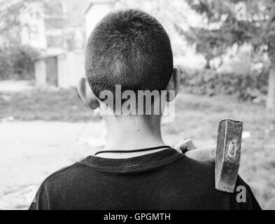 Kid avec marteau de retour, photo en noir et blanc. Banque D'Images