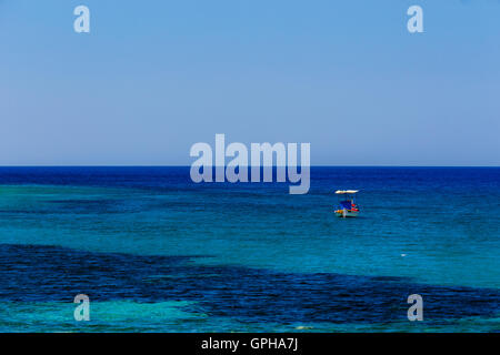 Bateau de pêche traditionnels en bois flottant sur les eaux colorées dans l'après-midi contre les eaux bleues, Laconie, Grèce Banque D'Images