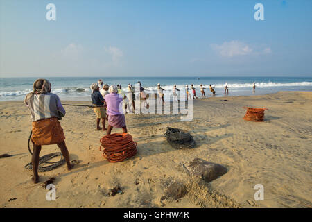 Le transport dans des filets de pêcheurs au lever du soleil, Vizhinjam Beach, Kovalam, Kerala, Inde, Asie Banque D'Images