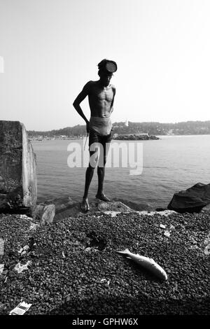 Pêcheur de poissons. Regardant sa prise du jour. Une vue de Vizhinjam, Kerala, Inde. Banque D'Images