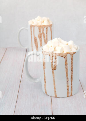 Chocolat chaud dans deux tasses en céramique blanche avec garniture guimauve Banque D'Images