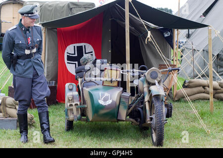 La Deuxième Guerre mondiale, officier allemand debout à côté d'une moto avec un side-car, avec le drapeau allemand la reconnaissance du véhicule Banque D'Images