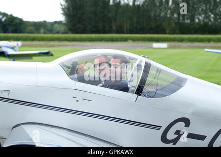 L'aérodrome de Shobdon, Herefordshire, UK - Septembre 2016 - Dominic Crossan ( premier plan pilote ) et Roger Scholes ( navigator derrière ) célébrer remportant cette années King's Cup air race en face de leurs cars avions. RV-6 La course est organisée par le Royal Aero Club et fonctionne sur une base de handicap avec une grande variété de types d'aéronefs course autour de l'aérodrome de Shobdon près de pylônes. La King's Cup air race a été lancé par le roi George V et tenue pour la première fois en 1922. Banque D'Images