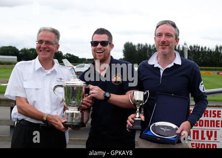 L'aérodrome de Shobdon, Herefordshire, UK - Septembre 2016 - Dominic Crossan ( pilote en centre ) et Roger Scholes ( navigator sur la droite ) Recevoir la Coupe du Roi de Marcus Woof ( à gauche ) d'Herefordshire Aero Club. La King's Cup air race est détenu par le Royal Aero Club et fonctionne sur une base de handicap avec une grande variété de types d'aéronefs course autour de pylônes, tenue cette année à l'aérodrome de Shobdon. La King's Cup air race a été lancé par le roi George V et tenue pour la première fois en 1922. Banque D'Images