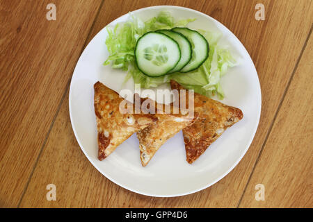 Samosas indiens avec salade verte sur plaque blanche sur la surface en bois Banque D'Images