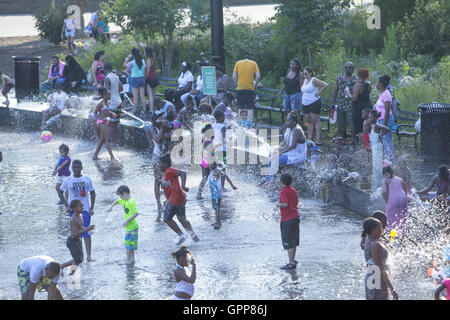 Les enfants comme les adultes se rafraîchir pendant la vague de chaleur de l'été 2016 à l'été au bord du lac au centre LeFrak water park à Prospect Park, Brooklyn, New York. Banque D'Images